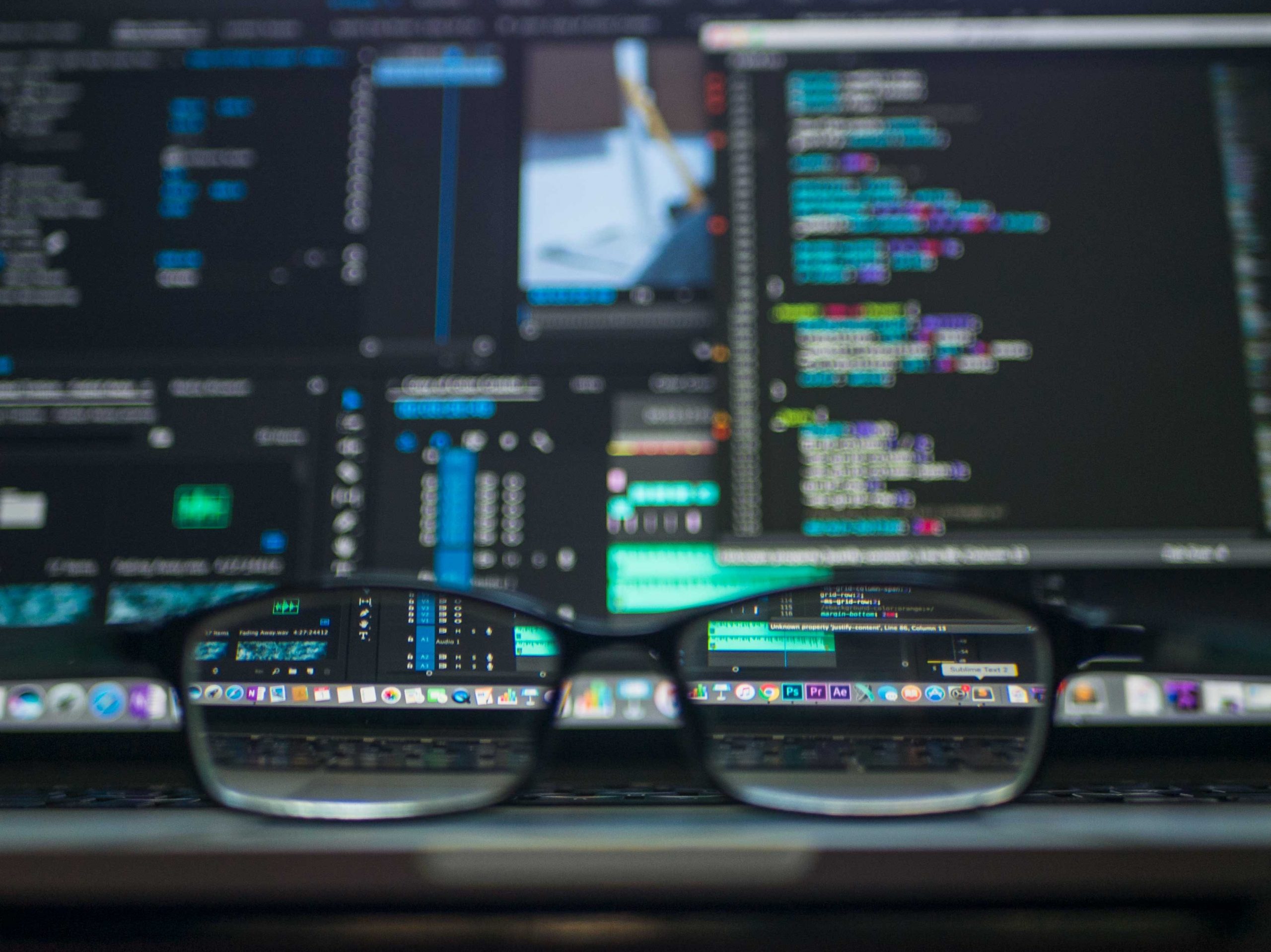 Glasses in front of a computer screen filled with code